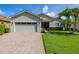 Charming single-story home with a brick driveway, two-car garage, and a beautifully manicured lawn at 4056 Ashton Club Dr, Lake Wales, FL 33859