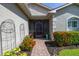 Charming front porch with lush plantings leading to a screened entryway and decorative architectural details at 4056 Ashton Club Dr, Lake Wales, FL 33859