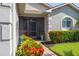 Inviting front porch with decorative plants, charming shrubbery, and a screened entryway at 4056 Ashton Club Dr, Lake Wales, FL 33859