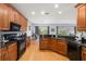 Spacious kitchen features wood cabinets, black countertops, and stainless steel appliances overlooking the breakfast nook at 4056 Ashton Club Dr, Lake Wales, FL 33859