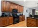 Well-lit kitchen boasts modern black appliances, wooden cabinetry, and sleek countertops, ideal for culinary pursuits at 4056 Ashton Club Dr, Lake Wales, FL 33859