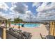 Relaxing outdoor pool area with lounge chairs, umbrellas, and a stunning lake view at 4056 Ashton Club Dr, Lake Wales, FL 33859