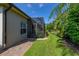 Exterior view of the screened-in patio area, lush landscaping, and a well-maintained yard at 4056 Ashton Club Dr, Lake Wales, FL 33859