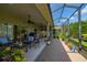 Wide screened patio area featuring brick pavers, ceiling fans, and comfortable seating with beautiful garden views at 4056 Ashton Club Dr, Lake Wales, FL 33859