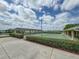 Well-maintained tennis courts with covered seating areas, surrounded by manicured landscaping at 4056 Ashton Club Dr, Lake Wales, FL 33859