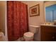 Bathroom with a toilet next to the tub with a patterned curtain and framed wall art at 408 Bloomingdale Dr, Davenport, FL 33897