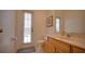Well-lit bathroom featuring a vanity with ample counter space, toilet, and access door at 408 Bloomingdale Dr, Davenport, FL 33897