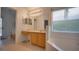Bright bathroom featuring a double vanity, tub under a window, and tile floors at 408 Bloomingdale Dr, Davenport, FL 33897
