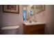 Bathroom vanity featuring a white sink and wood cabinet, complemented by essential toiletries and a clean toilet at 408 Bloomingdale Dr, Davenport, FL 33897