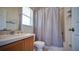 Bright bathroom with a shower/tub featuring a vanity, mirror, and shower curtain providing a clean and functional space at 408 Bloomingdale Dr, Davenport, FL 33897