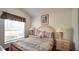 Comfortable bedroom featuring a decorative bed, bedside tables, and a bright window at 408 Bloomingdale Dr, Davenport, FL 33897