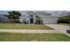 Beautiful home featuring a well-manicured lawn, lush shrubbery, and a classic two-car garage at 408 Bloomingdale Dr, Davenport, FL 33897