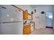 Corner view of the kitchen featuring light wood cabinets and white appliances at 408 Bloomingdale Dr, Davenport, FL 33897
