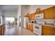 Bright kitchen featuring light wood cabinets, white appliances, and an adjacent dining area with views at 408 Bloomingdale Dr, Davenport, FL 33897