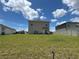 Large backyard with a two-story house, grass, and some landscaping at 464 Talisi Loop, St Cloud, FL 34771