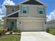 Charming two-story home featuring turquoise shutters, stone accents, and a well-manicured lawn at 464 Talisi Loop, St Cloud, FL 34771