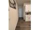 Hallway with wood floors, and white walls near a kitchen with white cabinets and countertops at 464 Talisi Loop, St Cloud, FL 34771