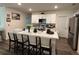 Kitchen with large island, stainless steel appliances, white cabinets, bar stools and wood flooring at 464 Talisi Loop, St Cloud, FL 34771