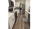 Modern kitchen featuring stainless steel appliances, white cabinets, and wood grain floors at 464 Talisi Loop, St Cloud, FL 34771