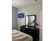 Clean bedroom featuring a TV and mirror above the dresser, with natural light from the window at 4862 Cayview Ave # 40409, Orlando, FL 32819