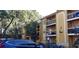 Condominium exterior with a yellow facade, multiple balconies, and a view of the surrounding greenery at 5287 Images Cir # 307, Kissimmee, FL 34746