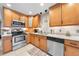 Modern kitchen featuring stainless steel appliances, granite countertops, and wood cabinetry at 6441 Nightwind Cir, Orlando, FL 32818