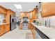 Well-lit kitchen with wooden cabinets, granite countertops, stainless steel appliances, and a skylight at 6441 Nightwind Cir, Orlando, FL 32818