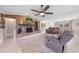Spacious living room with a brick fireplace, ceiling fan, large windows, and tile flooring at 6441 Nightwind Cir, Orlando, FL 32818