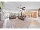 Spacious living room featuring tile flooring, neutral paint, ceiling fan, and entrance to kitchen at 6441 Nightwind Cir, Orlando, FL 32818