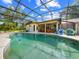 Backyard pool area with screened-in enclosure and string lights for evening enjoyment and safety, close to outdoor patio at 6441 Nightwind Cir, Orlando, FL 32818