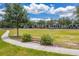Sidewalk and bench in a well-maintained neighborhood park with lush greenery at 7413 Bent Tree Loop, St Cloud, FL 34771