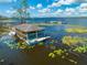 Water view of a covered boat dock with canoes, kayak, and boat on lake at 7413 Bent Tree Loop, St Cloud, FL 34771