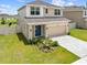 Exterior of a two-story home with a well-manicured front yard, a two-car garage, and a blue front door at 7413 Bent Tree Loop, St Cloud, FL 34771