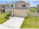 Exterior shot of a two-story home with a large driveway and a well-maintained lawn at 7413 Bent Tree Loop, St Cloud, FL 34771