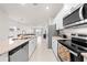 Modern kitchen with stainless steel appliances, granite countertops, white cabinets, and open concept to living area at 7413 Bent Tree Loop, St Cloud, FL 34771