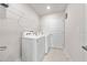 Efficient laundry room with a modern washer and dryer, plus ample shelving for storage at 7413 Bent Tree Loop, St Cloud, FL 34771