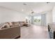 Bright and airy living room featuring a large sectional sofa, neutral color palette, and ample natural light at 7413 Bent Tree Loop, St Cloud, FL 34771