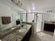 Bathroom with double sinks, granite countertops, and a glass-enclosed shower providing a modern and functional space at 820 Cambridge Dr, Winter Haven, FL 33881