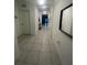 Bright hallway with tiled flooring leading to various rooms, decorated with mirror and wall art at 820 Cambridge Dr, Winter Haven, FL 33881