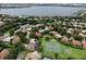 An aerial view showcases a neighborhood with tennis courts, a pond, lush landscaping, and well-maintained lawns at 8214 Lake Serene Dr, Orlando, FL 32836