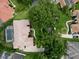 Aerial view showing a home with terracotta roof, a screened-in pool, manicured lawn and paved driveway at 8214 Lake Serene Dr, Orlando, FL 32836
