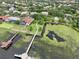 Aerial view of a lakefront house with a boat dock and long pier surrounded by lily pads and grassy shoreline at 8214 Lake Serene Dr, Orlando, FL 32836