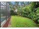 Landscaped backyard featuring green grass, mulch beds, privacy shrubs and mature trees at 8214 Lake Serene Dr, Orlando, FL 32836