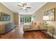 This bedroom has hardwood floors, a TV, large windows, and a tufted headboard at 8214 Lake Serene Dr, Orlando, FL 32836