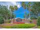 Community sign for Phillips Landing with palm trees and colorful landscaping set against a clear blue sky at 8214 Lake Serene Dr, Orlando, FL 32836