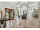 Grand foyer with tile flooring leads to the dining room framed by elegant columns and a stunning chandelier at 8214 Lake Serene Dr, Orlando, FL 32836