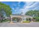 Community entry gate with brick accents, decorative windows, and lush landscaping under a blue sky at 8214 Lake Serene Dr, Orlando, FL 32836