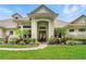 An alluring front entrance highlighted by meticulously manicured landscaping, leading to a stunning single-story home at 8214 Lake Serene Dr, Orlando, FL 32836