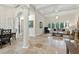 A spacious living room with tiled floors and white columns featuring large windows with views of the backyard at 8214 Lake Serene Dr, Orlando, FL 32836