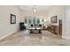 A spacious living room with tiled floors and large windows offering serene views of the backyard and pool at 8214 Lake Serene Dr, Orlando, FL 32836